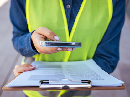 inspector with safety coat taking pic of information