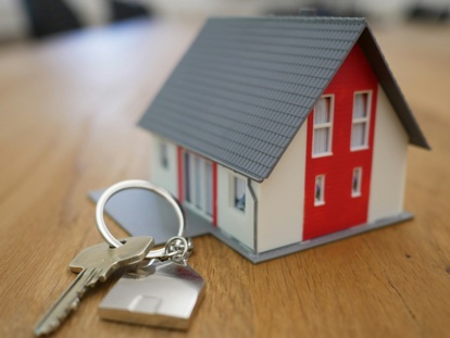 small model house with key on wood table