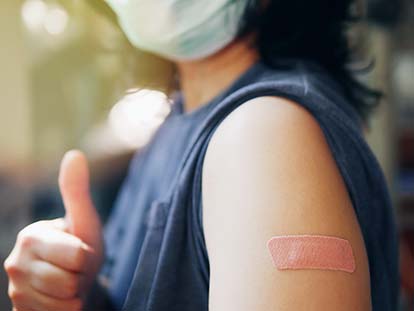 person giving thumbs up after receiving a shot